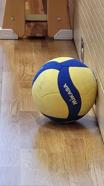 Ein Volleyball liegt auf dem Hallenboden