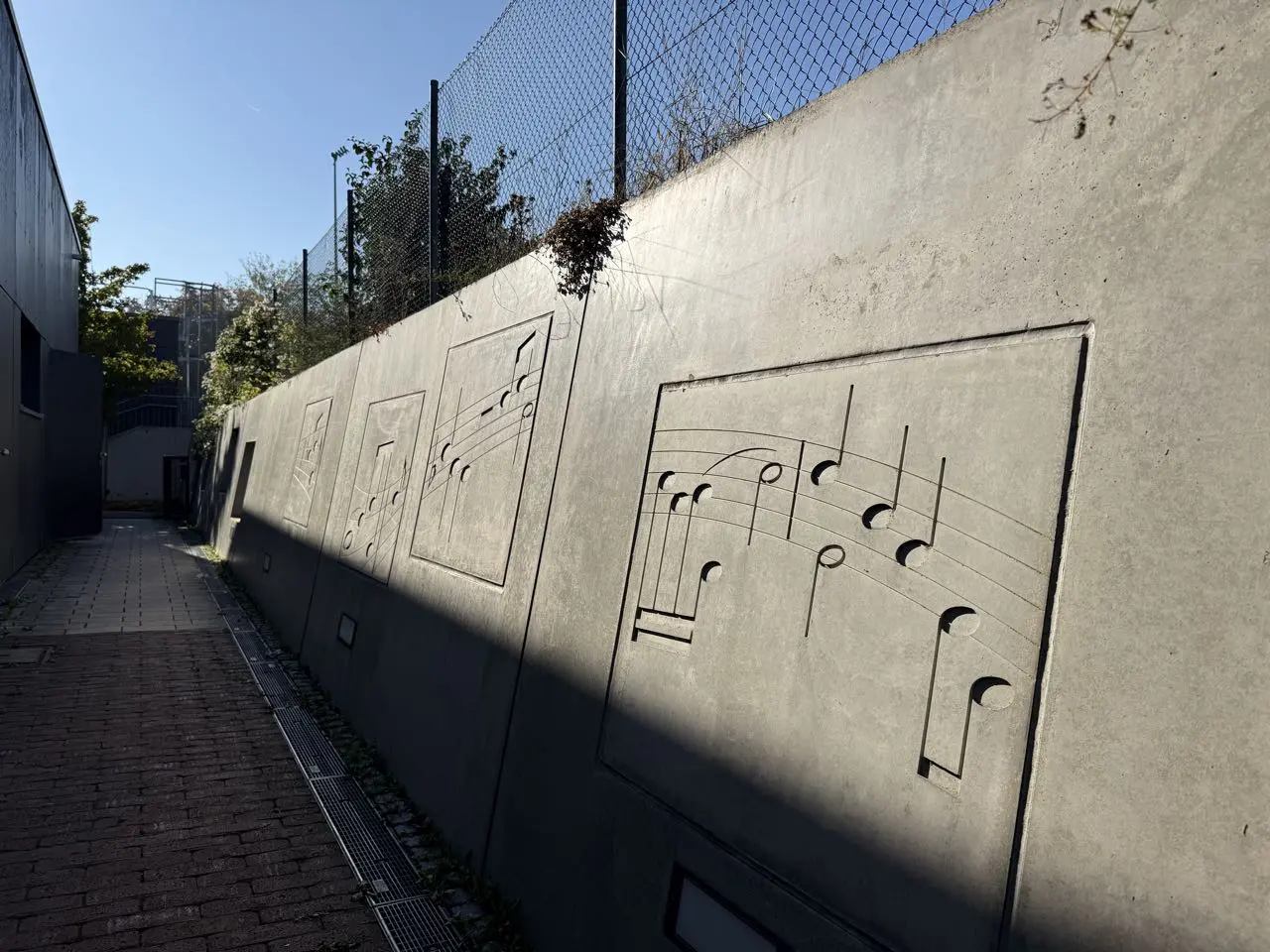 Musiknoten als Relief in der Betonwand am Schulweg