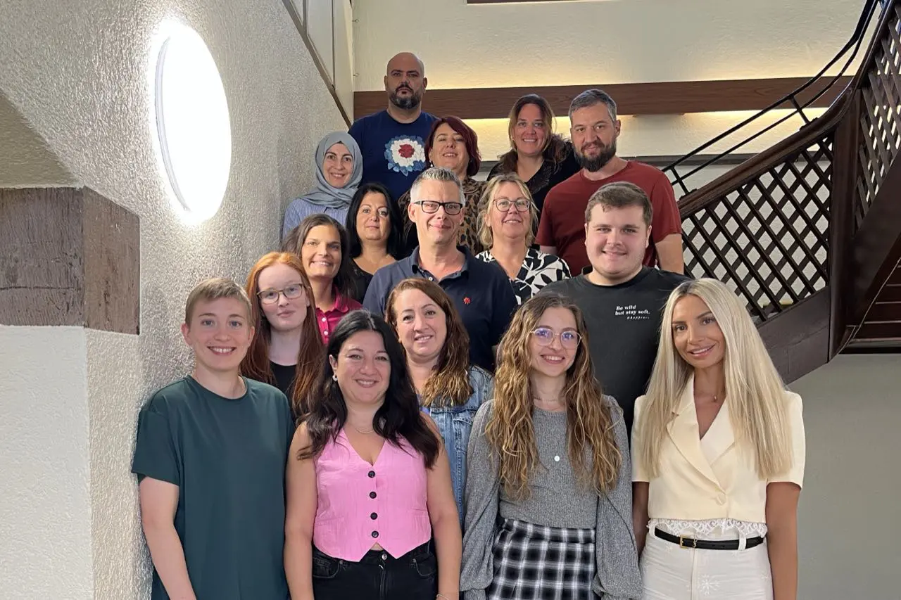Gruppenfoto des Teams im sozialpädagogischen Bereich auf der Treppe im Altbau
